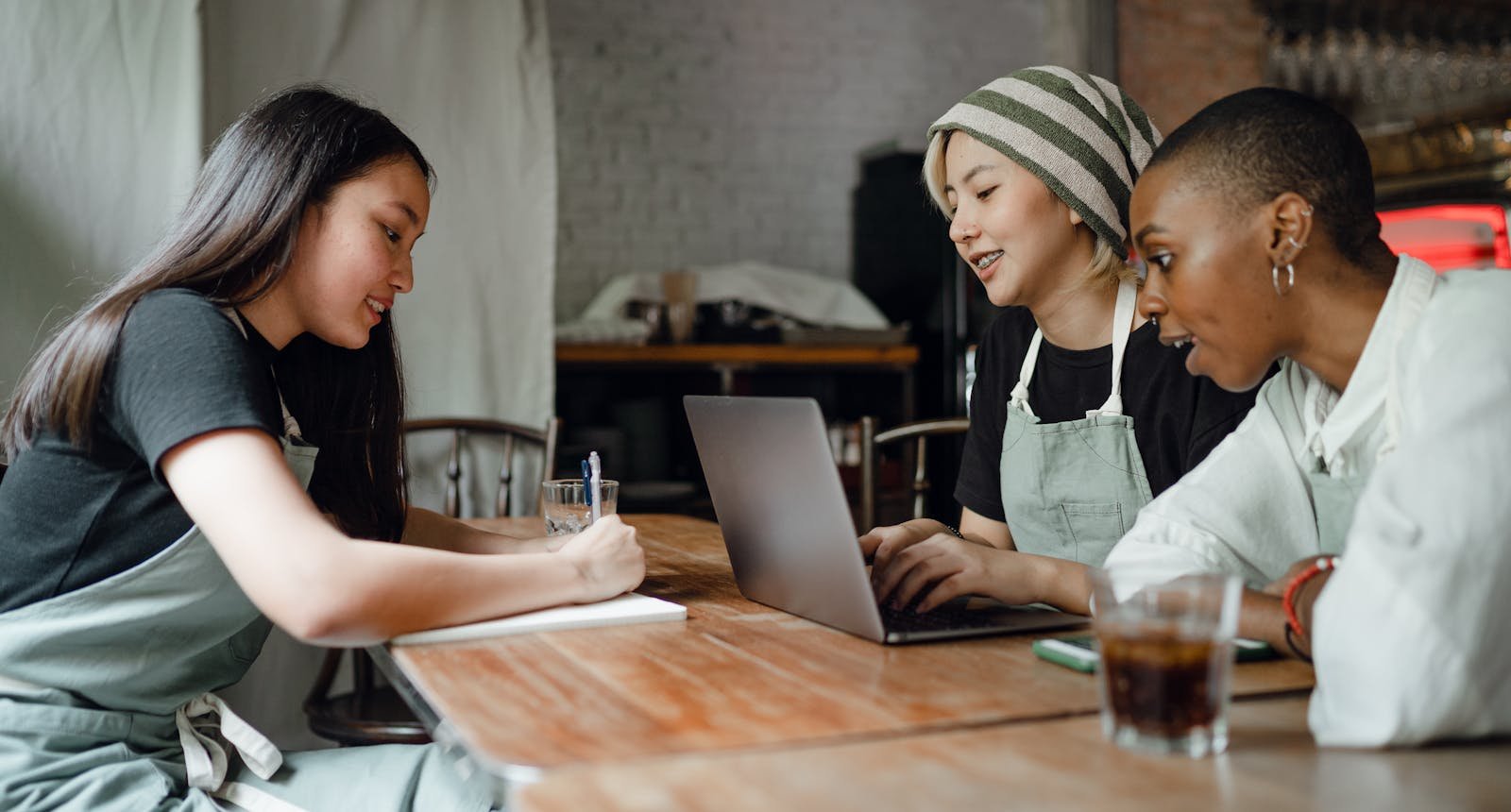 Small business team reviewing client details and notes together at a laptop.