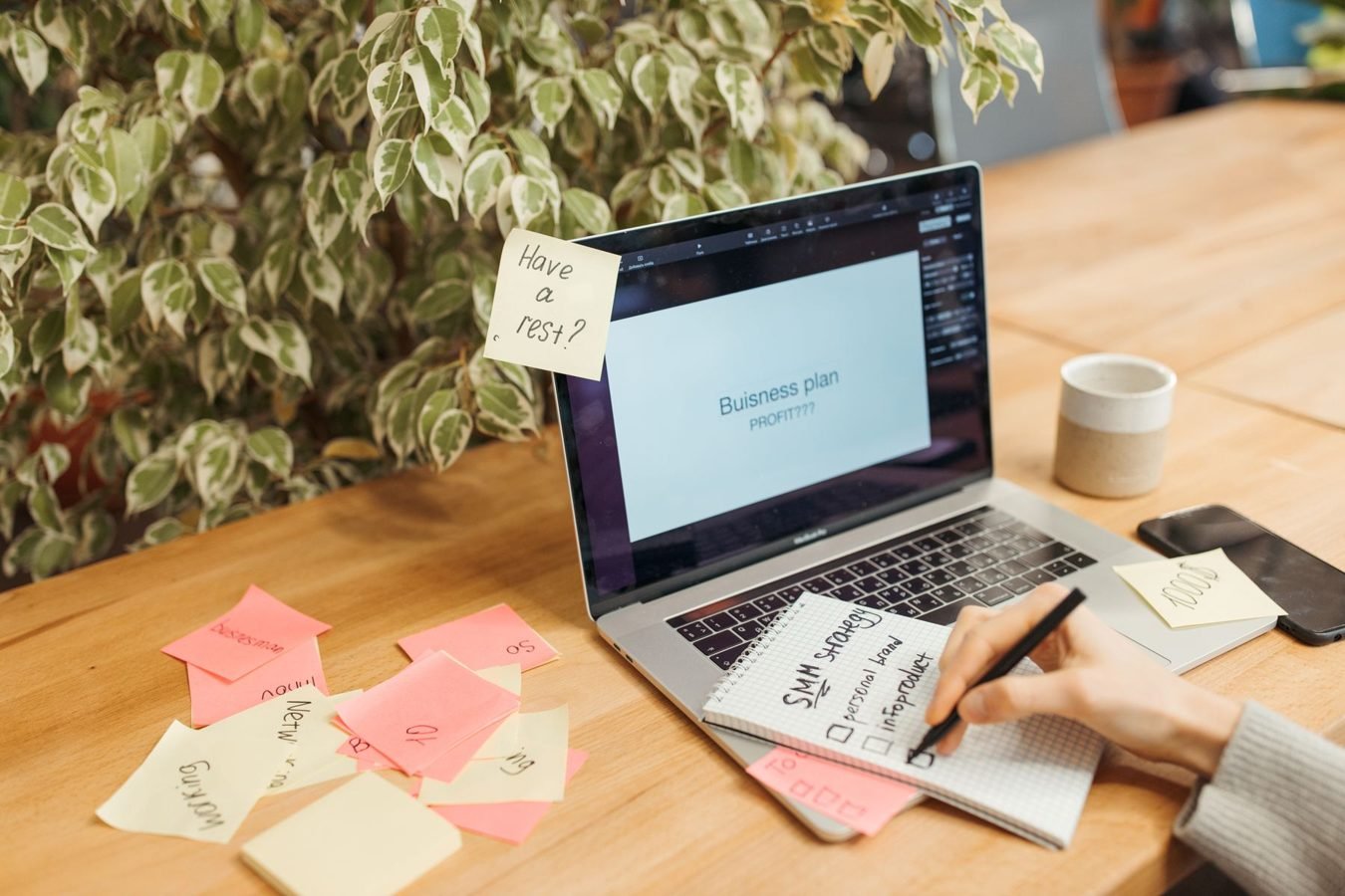 Laptop and sticky notes used to organize a digital product validation plan.